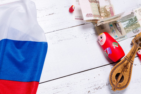 Russian symbols matryoshka, balalaika, rubles cash and flag of russian federation on wooden background.の写真素材