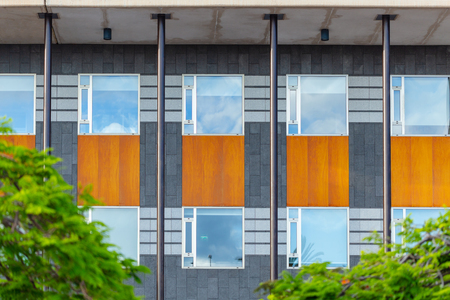 Facade of offices building, repeating windows, steel poles and wooden plank. Modern architecture.の写真素材