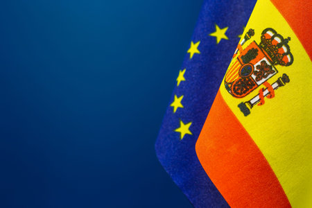 Flags of Spain and United Europe with blue background empty space for your text on left.の写真素材