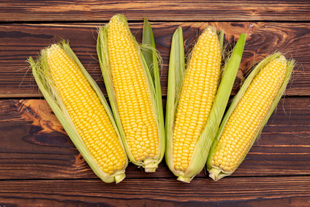 Corn cobs on wooden table.の写真素材