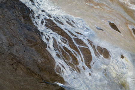 Top down view on abstract patterns and shapes of mineral waste rivers from power plant.