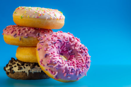 Pile of colorful donuts on blueの写真素材