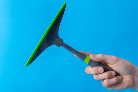 Hand keeps squeegee, isolated photography.