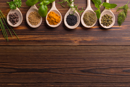 Mixed spices and herbs on wooden spoons with copy space.の写真素材