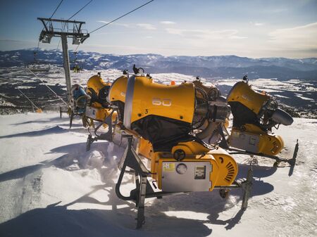 Yellow snow cannons on slope in winter time.の写真素材