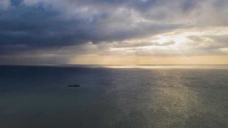 Aerial panoramic view on stormy clouds and ocean with industrial ship.の写真素材