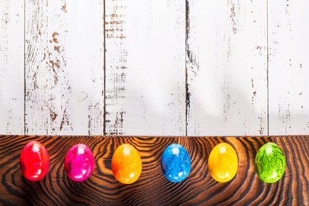 Easter wooden background with colored eggs.