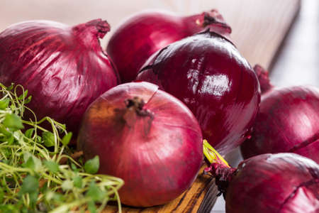 Red onions with thyme on wooden board.の写真素材