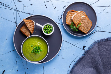 Fresh homemade peas cream soup with mint and toasted bread.の写真素材