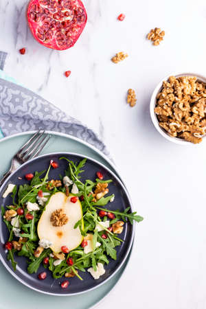 Fresh and healthy salad with arugula, gorgonzola cheese, pomegranate and pears.の写真素材