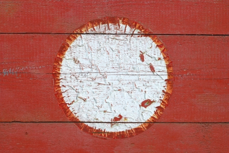 white round with a red border in the old style, scarred, red wood backgroundの写真素材