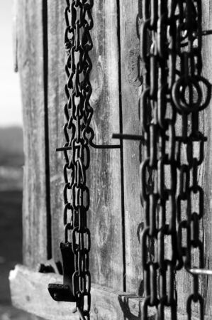 chains hanging on the old door, black and whiteの写真素材