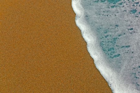 Foam on the beach, taking photos from above the sandの写真素材