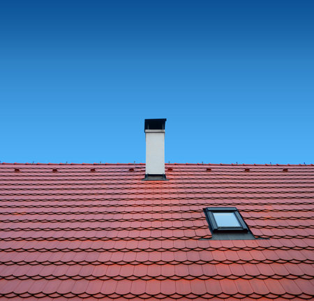 roof with brown tiles on a background of blue sky, new roofの写真素材