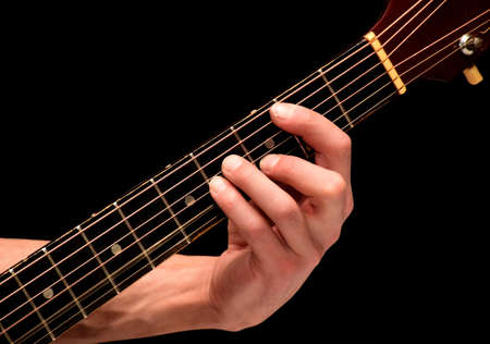 On a black background the playing guitarist chords on stringsの写真素材
