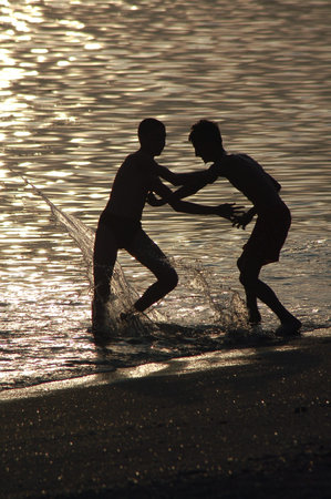 Silhouette of boys on beachの写真素材