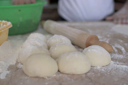 Lahmacun Dough Balls Rady For Roll  With Wooden Rolling Pin on Kitchen Deskの写真素材