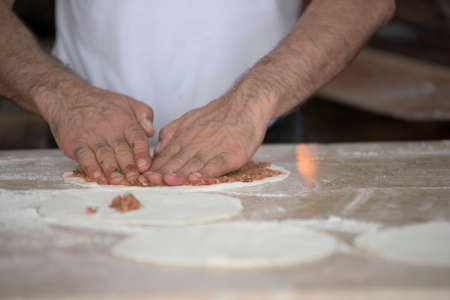 Man Preparing Lahmacun Dough With Hands on the Kitchen Deskの写真素材