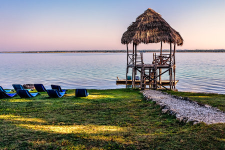 Lake  vista during early morning hours under clear apricot blue skies with swimming facilities at the lake shoreの写真素材