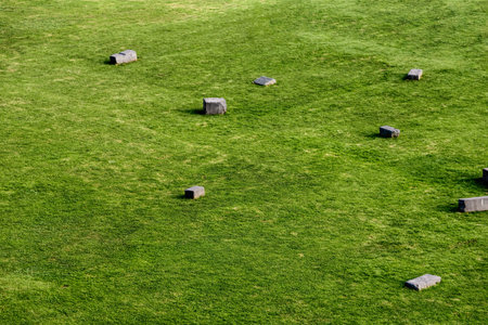 Green fields with ancient stones from Incas in a Peruvian City high in Andes Mountainsの写真素材
