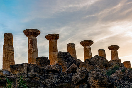 Antique city columns under sunset with scattered cloudsの写真素材