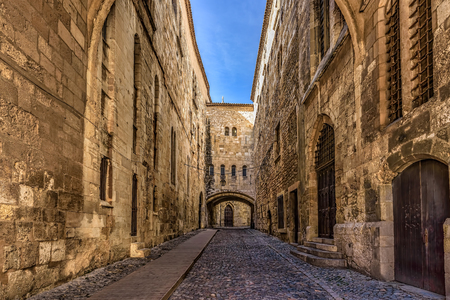 Cobblestone street between high walls in a medieval cityの写真素材