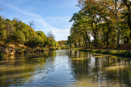 Water canal in southern French town under clear blue skiesの写真素材