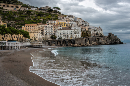 Small southern italian town with a wide beach and calm foamy wavesの写真素材