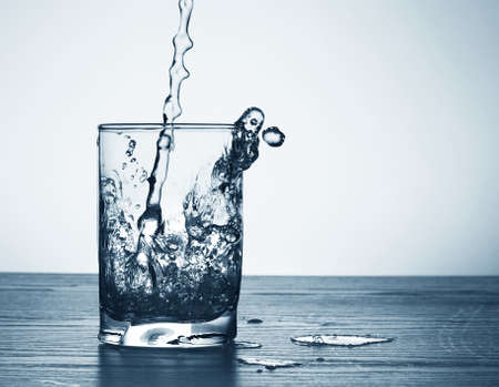 Water flowing and splashing from a glassの写真素材
