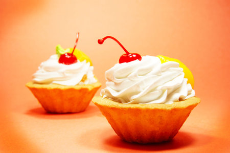 Two delicious fruit cakes on a red backgroundの写真素材