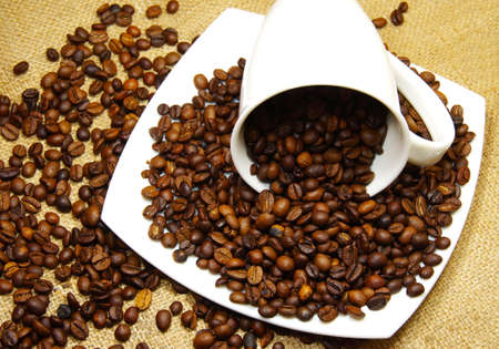 cup, saucer and coffee beans on canvas backgroundの写真素材