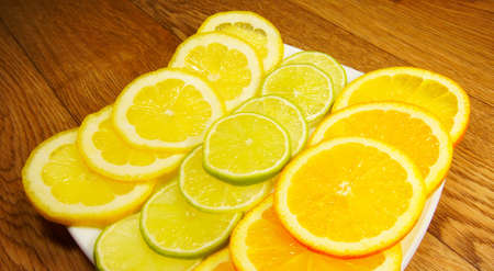 Assorted fruits on saucer on a wooden backgroundの写真素材