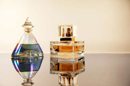 two bottles of perfume on mirror surfaceの写真素材
