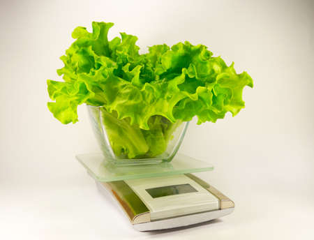 electronic scale with a green salad isolatedの写真素材