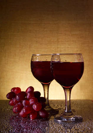 two glasses of red wine and grapesの写真素材