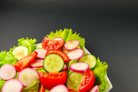 vegetable salad on white plate on dark backgroundの写真素材
