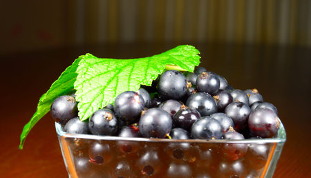 Black currant with green leaf on a table