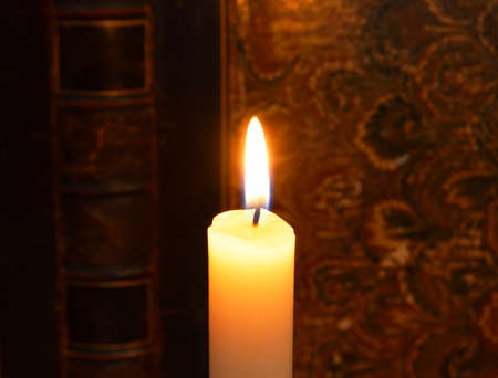 burning candle and the antique book backgroundの写真素材