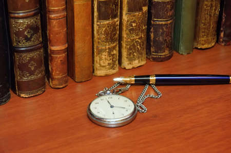 antique book, clock and pen on the shelfの写真素材