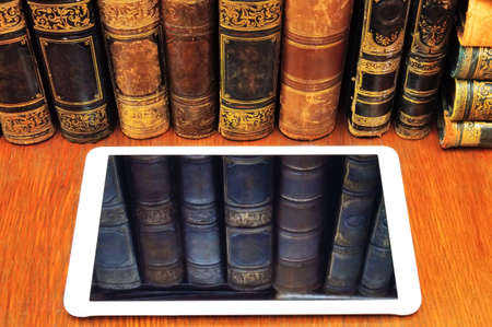 reflection of old books in the tablet pcの写真素材