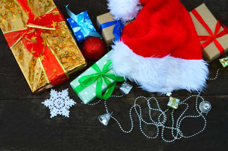 Christmas gifts and Santa hat on wooden backgroundの写真素材