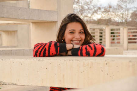 Young brunette girl smiling outdoor with red and black clothes and a hand watchの写真素材