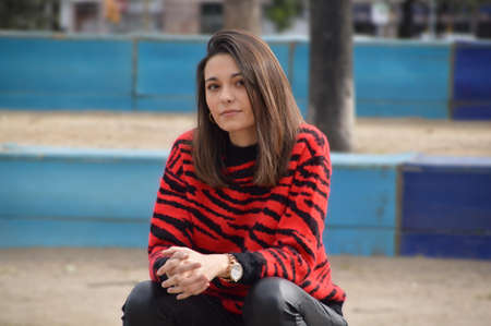 Young girl sitting in the parck with a hand watchの写真素材