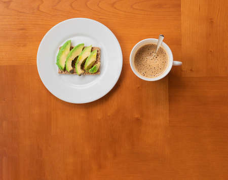 Breakfast, avocado toast with cup of coffee in a wooden tableの写真素材