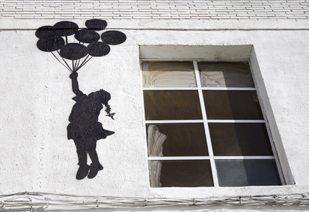 Girl with balloons flying over the wall, fantasy and imagination
