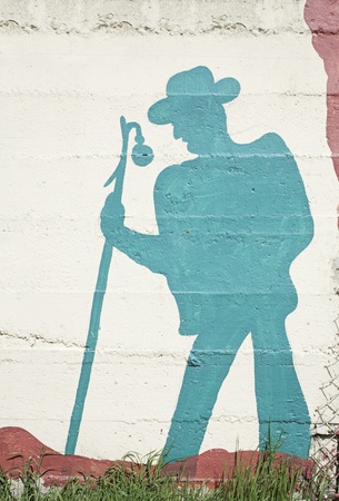 Pilgrim with backpack and walking stick drawn on wall, urban decorationの写真素材
