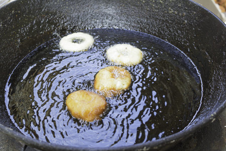 Doughnuts in oil in skillet restaurant, food