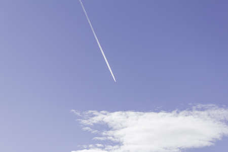 Summer sky with white clouds and a trail outdoorsの写真素材