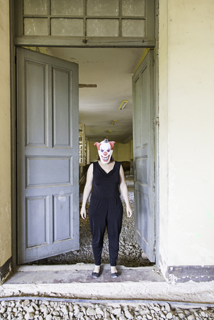 Clown in abandoned house door, fear and halloweenの写真素材