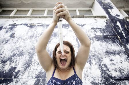 Dangerous young girl with knife, fear and violenceの写真素材
